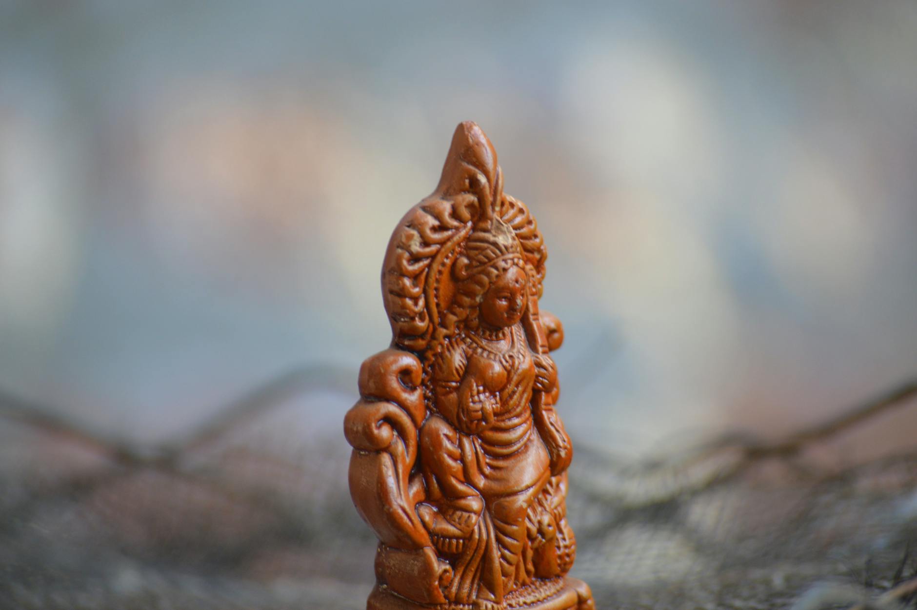 close up shot of a wooden statuette of hindu god lakshmi