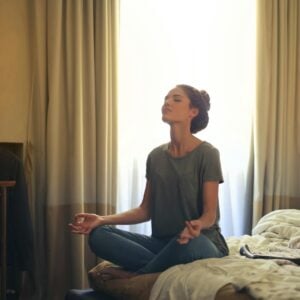 woman meditating in bedroom